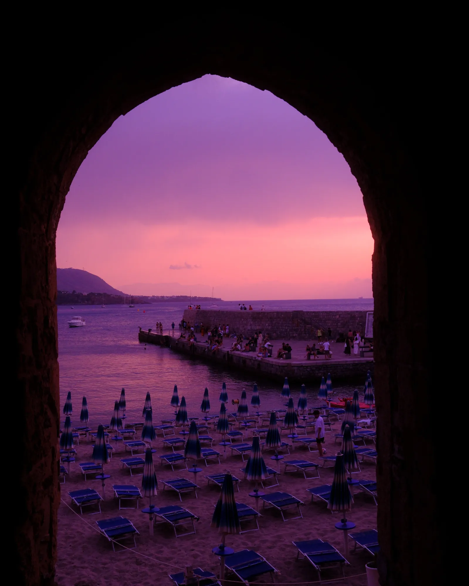 Porta Pescara at sunset Porta Pescara, an ancient stone arch in Cefalù framing a pink sunset over the sea