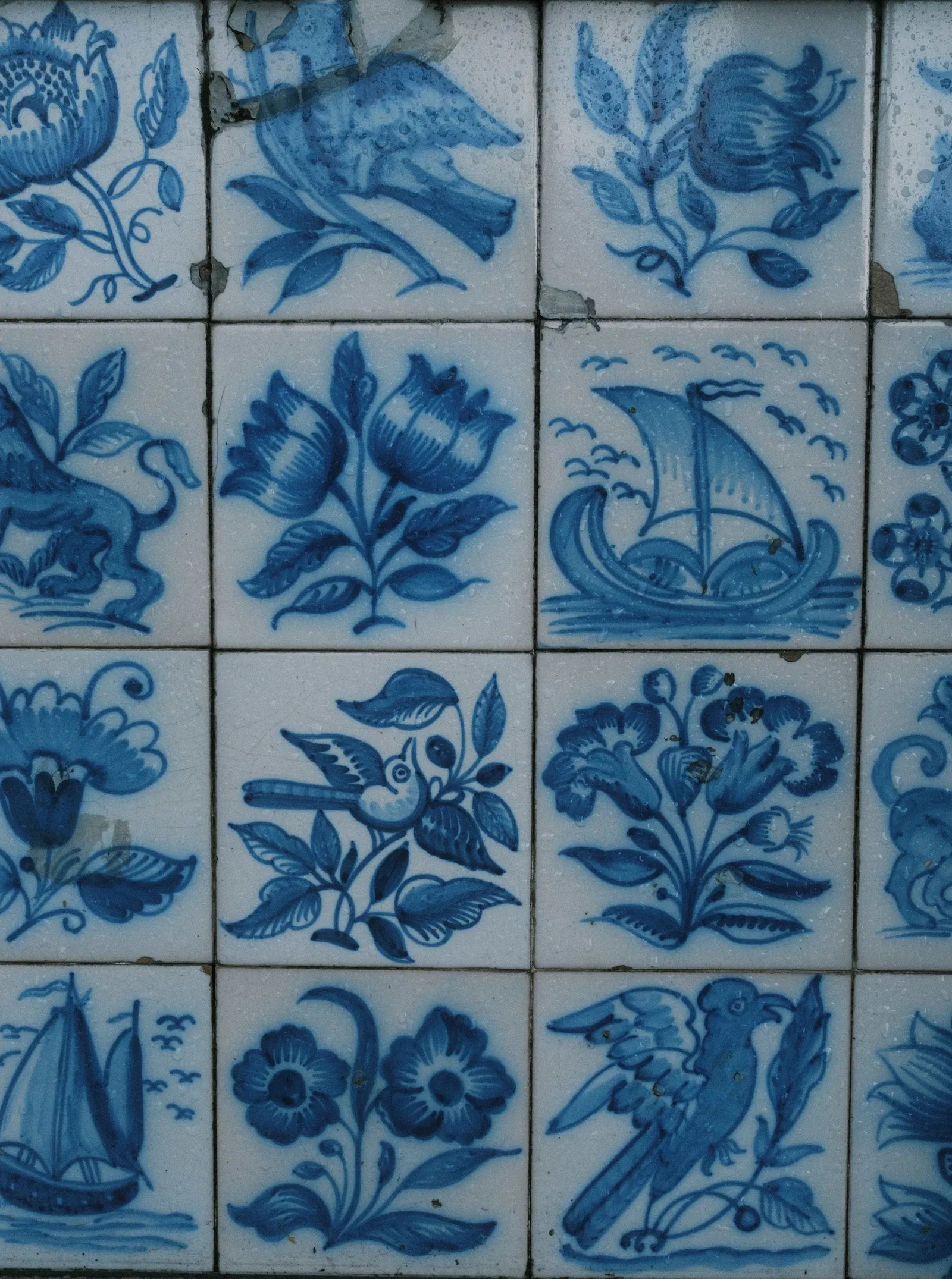 Antique blue and white Portuguese tiles painted with flowers, birds and sailing ships