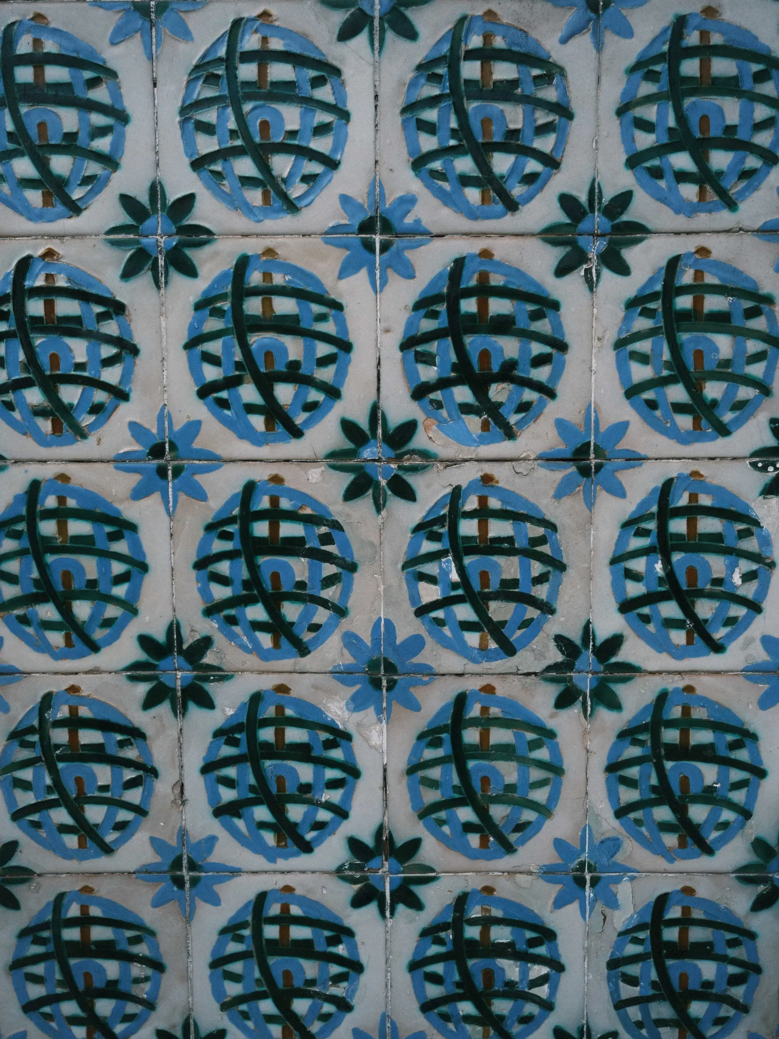 Lisbon azulejos in blue and green with a repeating armillary sphere motif