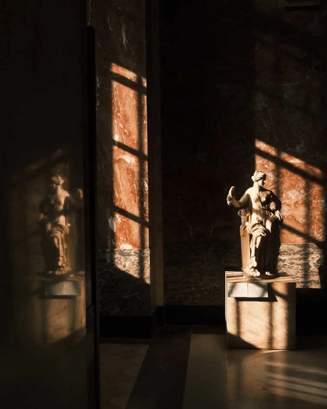 Statue in warm window light, interior photograph by xere.my